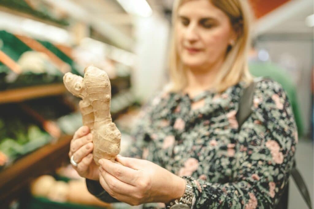 Frau kauft Ingwer im Supermarkt