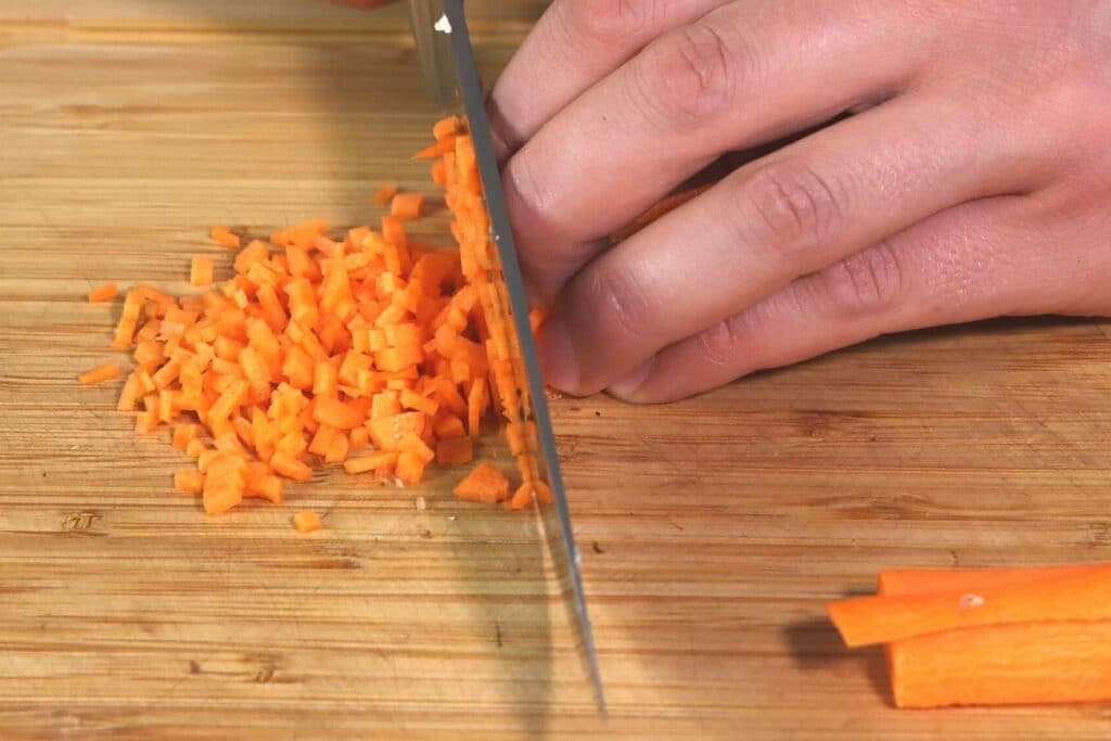 Möhren mit Messer klein schneiden