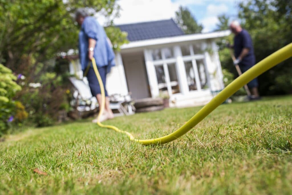 Pflanzen mit Gartenschlauch bewässern