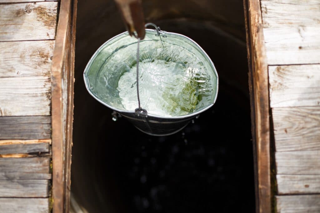 Eimer mit frischem Wasser in Brunnen