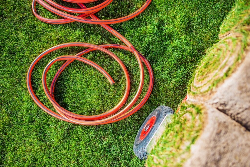 Wasserschlauch neben Rollrasen