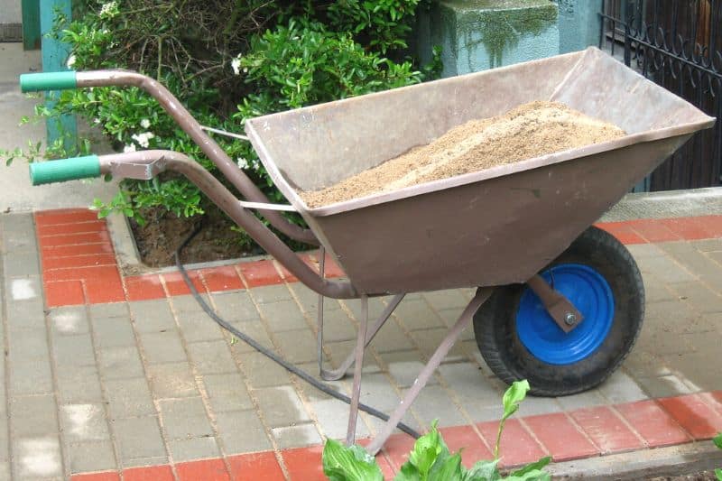 Schubkarre voller Sand im Garten