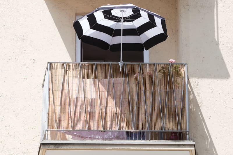 Sonnenschirm auf Balkon an Brüstung festgemacht